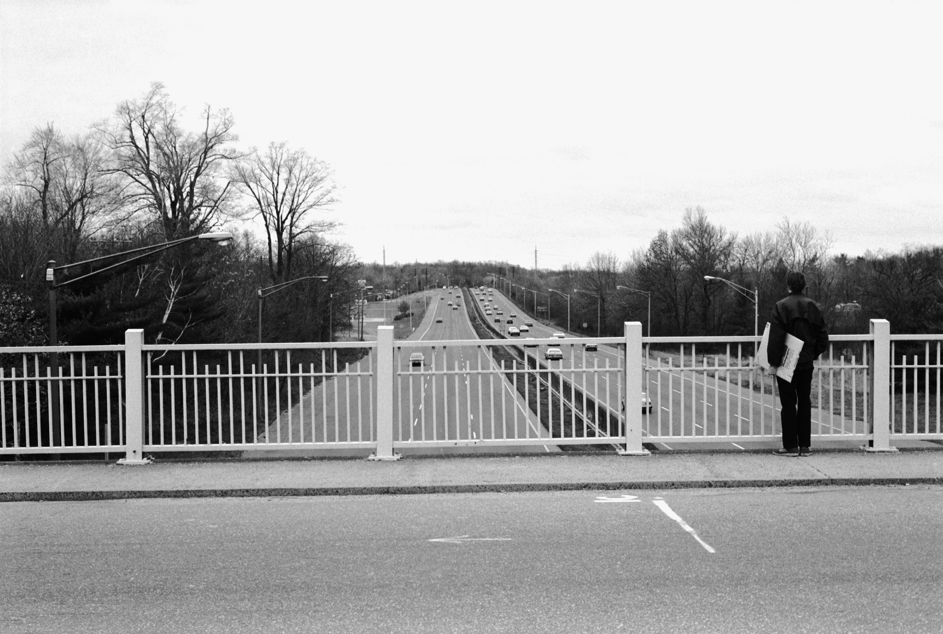 man carrying a box of Kodak paper on highway overpass