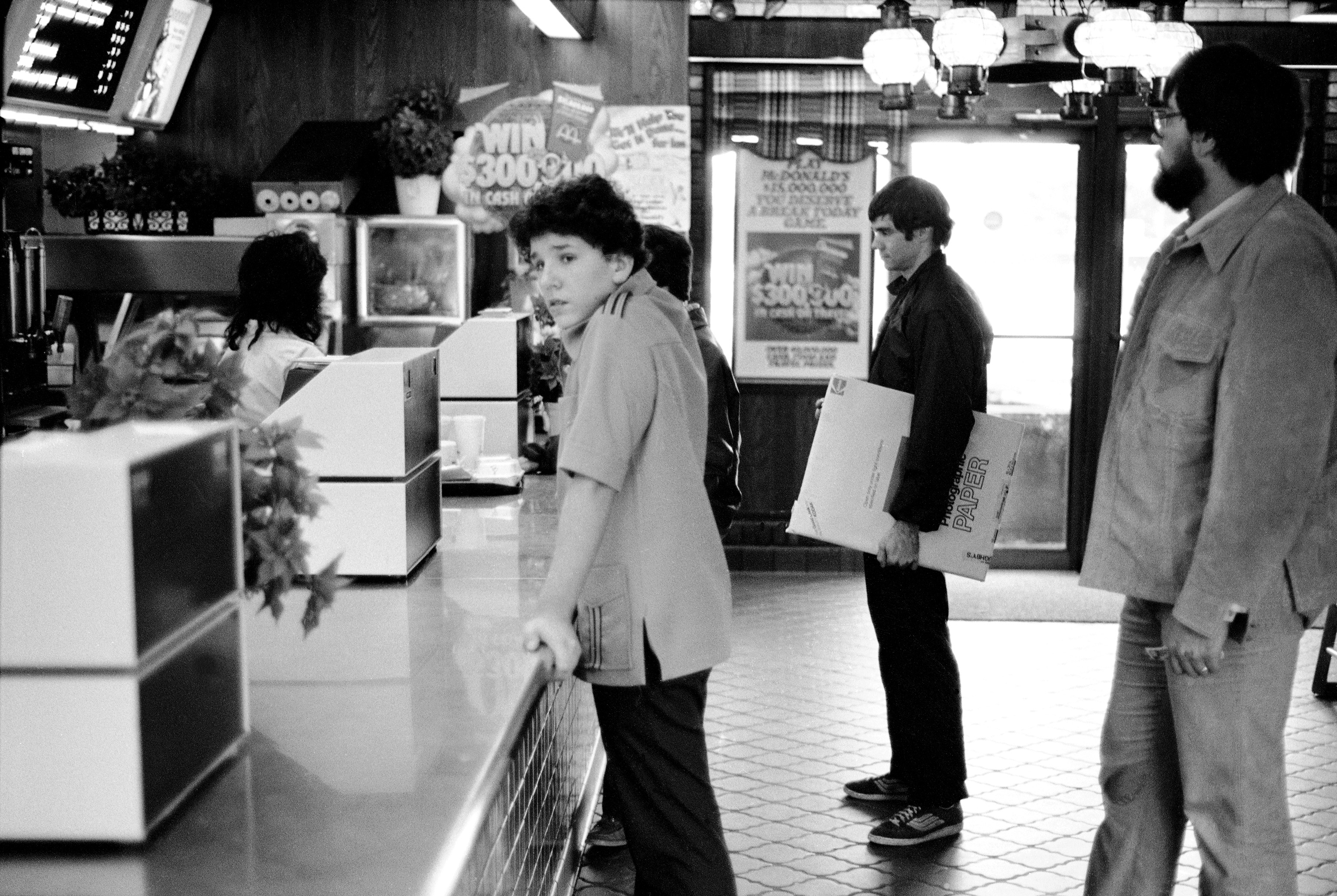 man carrying a box of Kodak paper in a store