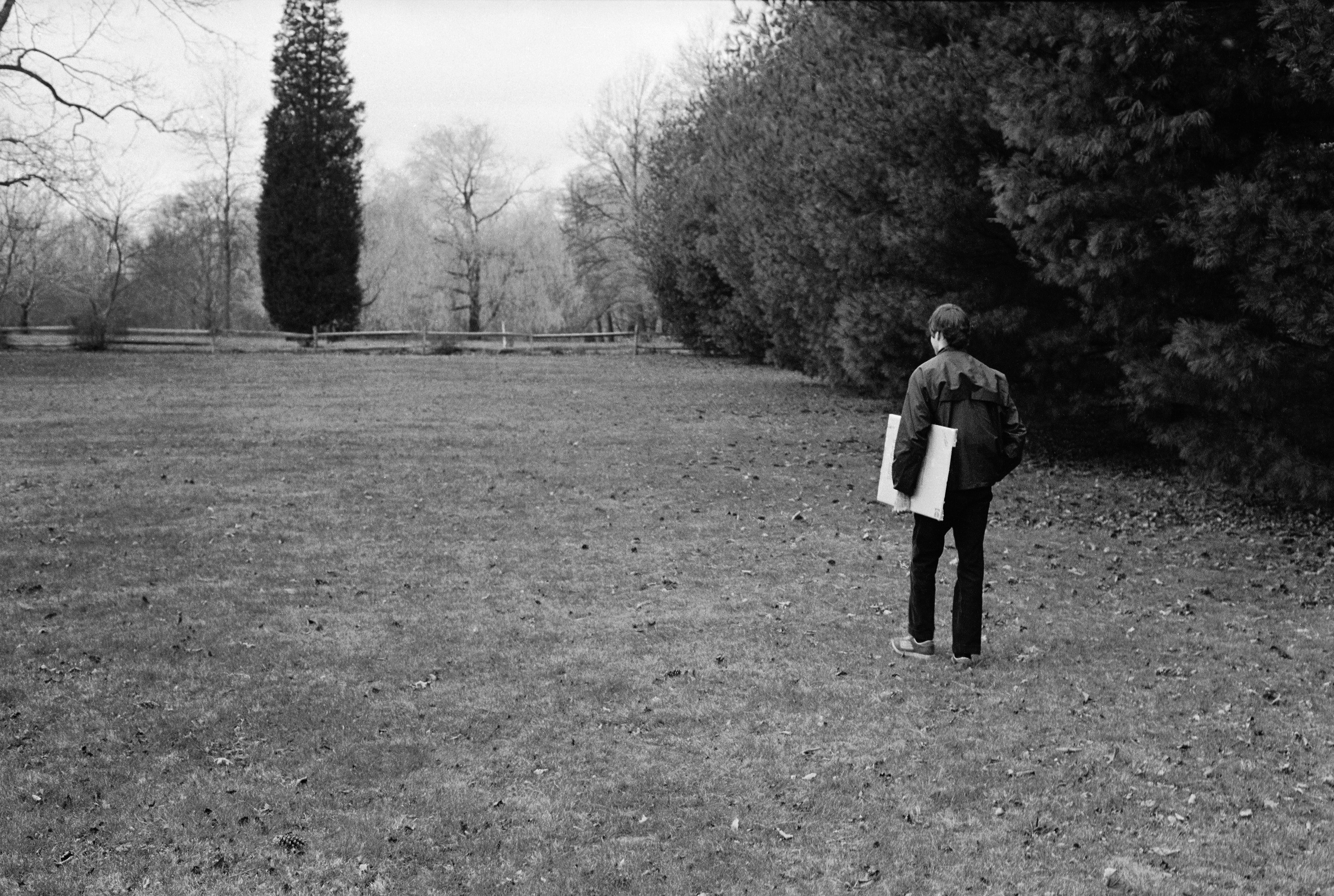man carrying a box of Kodak paper on a lawn